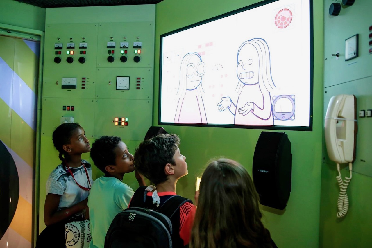 Visitors listen obediently to explanations in Room 2: The Indoctrination Lab